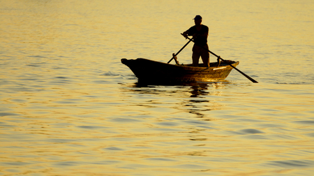 boat with a man of the sea at sunset,Venice, Italyの写真素材