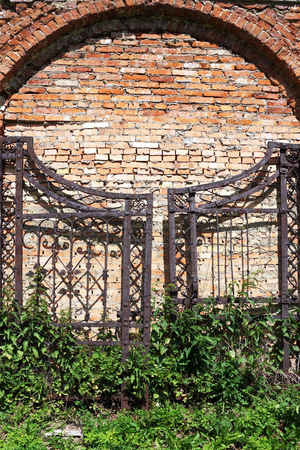 old iron gates on a brick masonry の写真素材