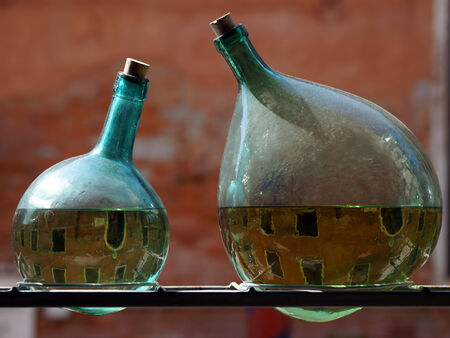 two green bottles with reflection Venetian canals, Venice, Italy の写真素材