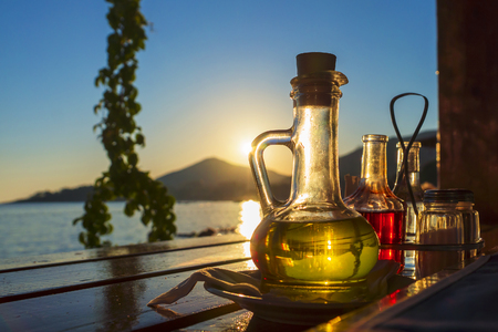 bottle with olive oil on a background of sea sunsetの写真素材