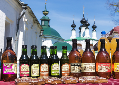 SUZDAL, RUSSIA - MAY 10: Mead and sbiren -Traditional Russian alcohol at the souvenir counter on the background of the most beautiful churches in Suzdal May 10, 2015のeditorial素材