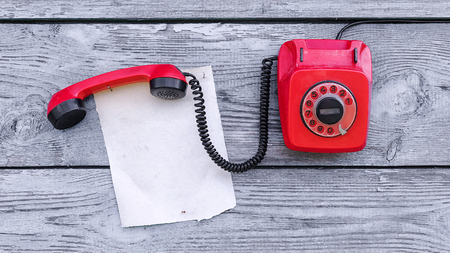 Vintage red phone and a piece of paper to writeの写真素材