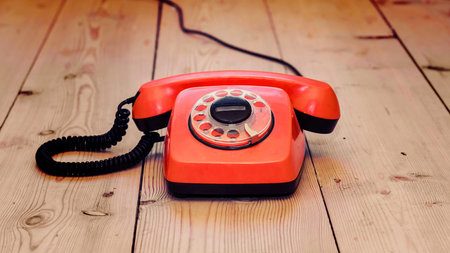 red dial phone on a wooden backgroundの写真素材
