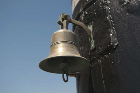 the old ship's bell on the background of blue skyの写真素材