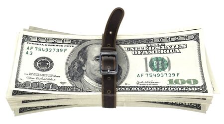 dollar bills squeezed together by leather belt. isolated on white background.の写真素材