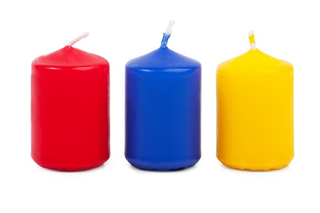 Three little colored candles squat on a white backgroundの写真素材