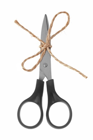 Scissors with blades tied with twine on a white backgroundの写真素材