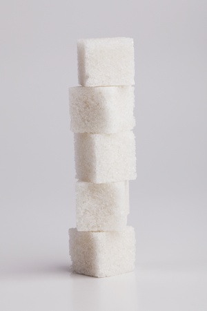 Five lumps of sugar on each other on a gray backgroundの写真素材