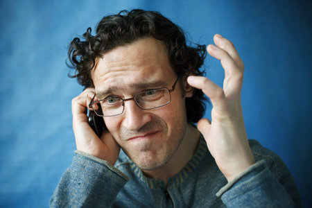 The man in spectacles emotional talking on a cell phone