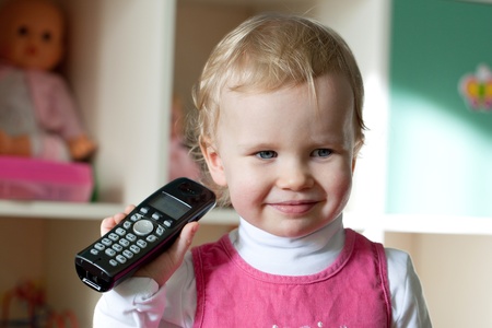 The little girl in a pink dress black handsetの写真素材