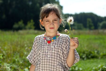 Girl with a dandelion hot sunny dayの写真素材