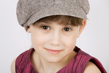 Pretty girl in a gray woolen cap with light backgroundの写真素材