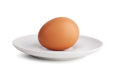 Boiled egg in a porcelain dish on a white backgroundの写真素材