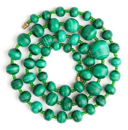 Beads made of malachite, rolled in a spiral on a white backgroundの写真素材