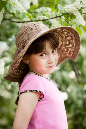 Portrait of little coquette in a wicker hatの写真素材