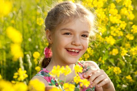 Cheerful girl in a light dress of flowersの写真素材