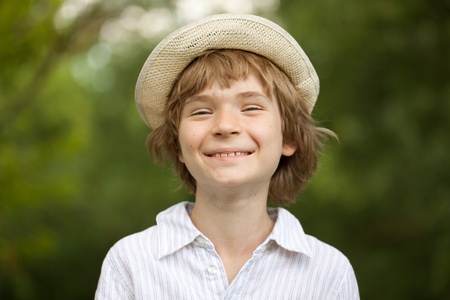 Cheerful blonde boy in a straw hatの写真素材