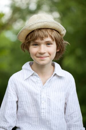 Portrait of blond boy in a wicker hatの写真素材