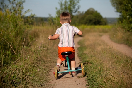 Little boy rides a tricycle on the roadの写真素材
