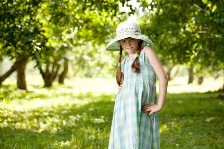 Girl in the hat and dress of apple orchardの写真素材