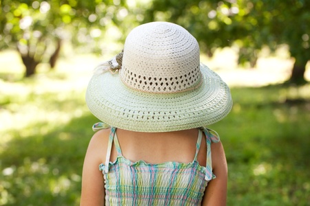 Girl in a wide-brimmed hat standing with his back to usの写真素材