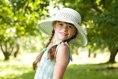 Charming girl in a big wicker hatの写真素材