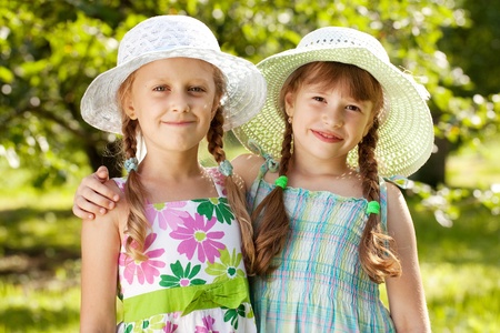 Two girlfriends in hats and summer dressesの写真素材