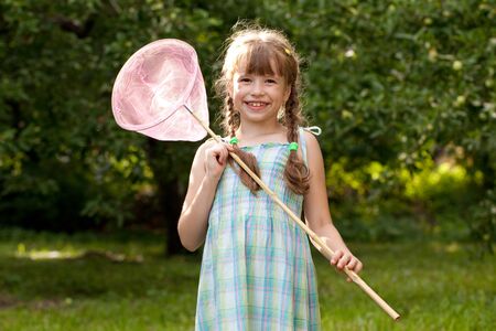 Funny little girl with a net for catching butterfliesの写真素材