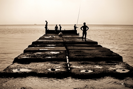 Old sea pier with people who fishの写真素材