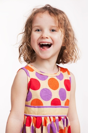 Happy little girl in a bright color dressの写真素材
