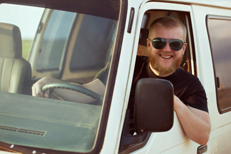 Smiling driver in sunglasses driving a car