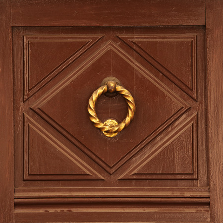 Antique brass doorhandle on a wooden doorの写真素材