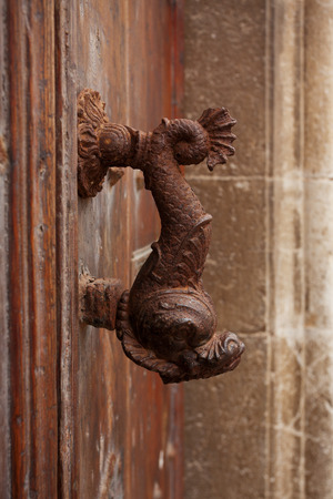 Old doorhandle in the form of an iron fishの写真素材