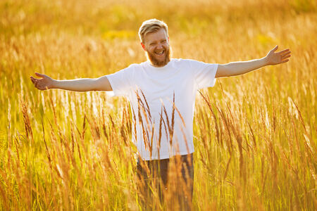 Happy bearded man in a field of grassの写真素材
