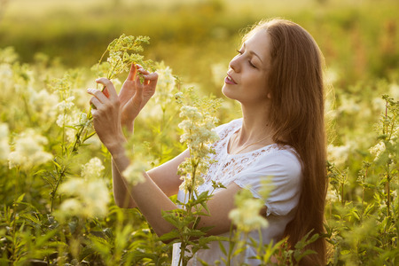 Happy beautiful girl among the high wildflowersの写真素材