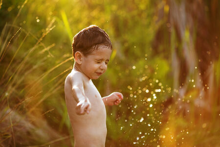 Little boy in the summer of splashing waterの写真素材