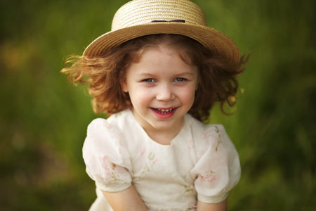 Happy cheerful girl in a straw hat