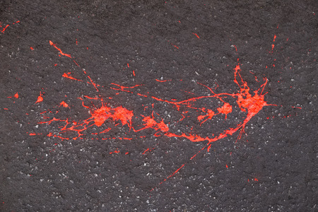 Blot of red paint on a gray pavementの写真素材