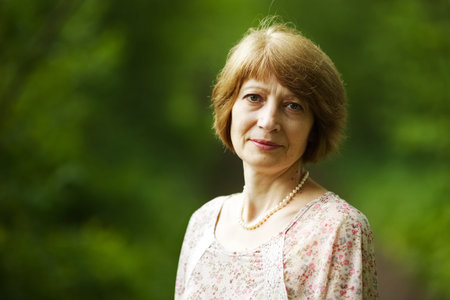 Beautiful elderly woman with pearl beads on a neckの写真素材