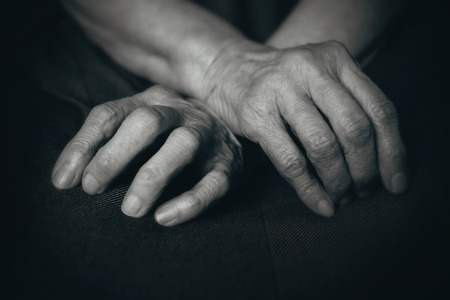 Fingers of the old man's hands in his lapの写真素材