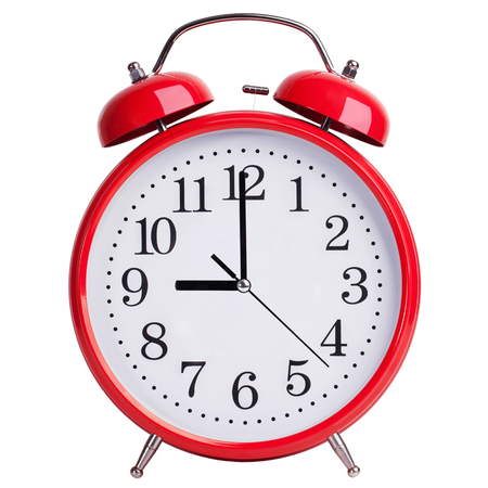 Round red alarm clock shows exactly nine o'clockの写真素材