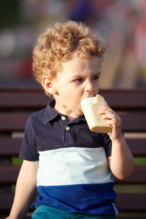 Little boy in t-shirt eats ice creamの写真素材