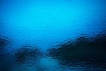 Transparent background in a dark blue wavy glassの写真素材