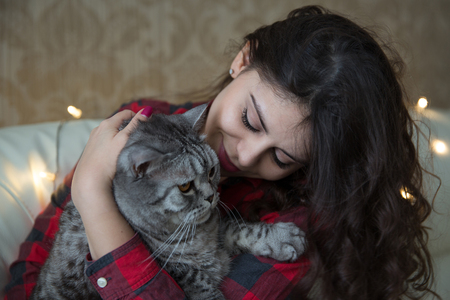 Long-haired young woman with a big gray catの写真素材