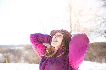 Happy smiling girl in a knitted burgundy hat and jacketの写真素材