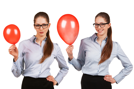 Cheerful girl in glasses with inflated red balloonの写真素材