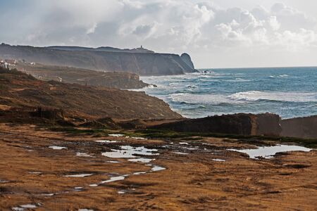 Seascape with clouds and a lighthouse in the distanceの写真素材