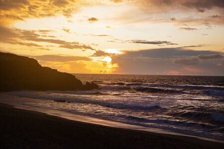 Seascape with the sun setting in the cloudsの写真素材