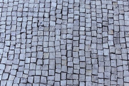 Fragment of a sidewalk paved with gray stoneの写真素材