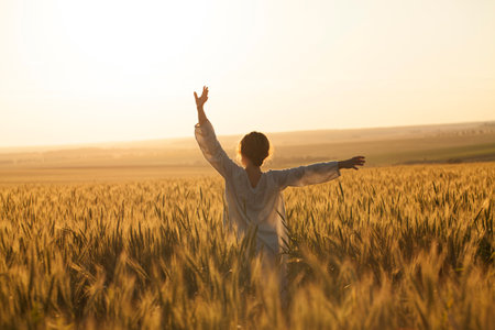 Happy girl in a dress in the middle of a field of ripe ryeの写真素材
